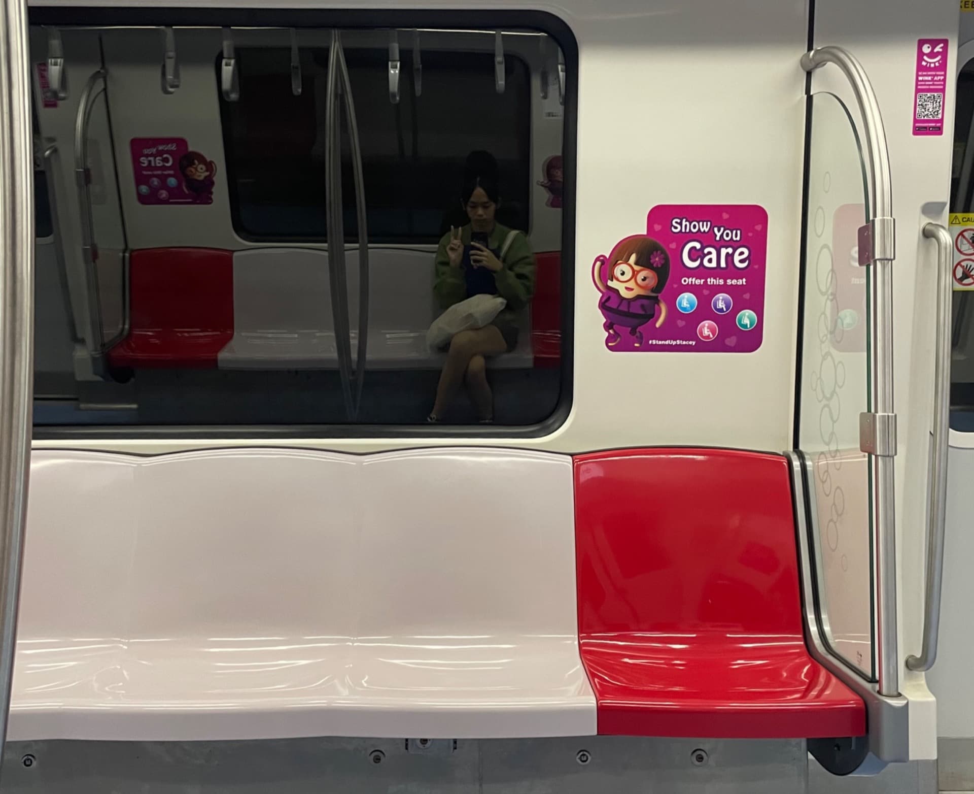 The interior of a Singapore MRT carriage with priority-seat stickers